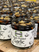 Load image into Gallery viewer, side view of several rows or 16 ounce jars of pickled black garlic